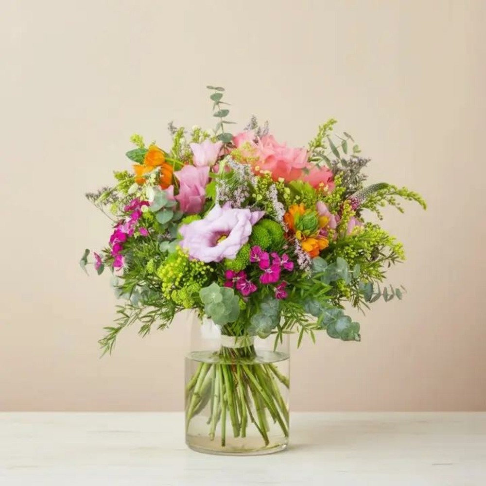 Bouquet de fleurs fraîches avec des roses roses, des lisianthus violets et des fleurs orangées