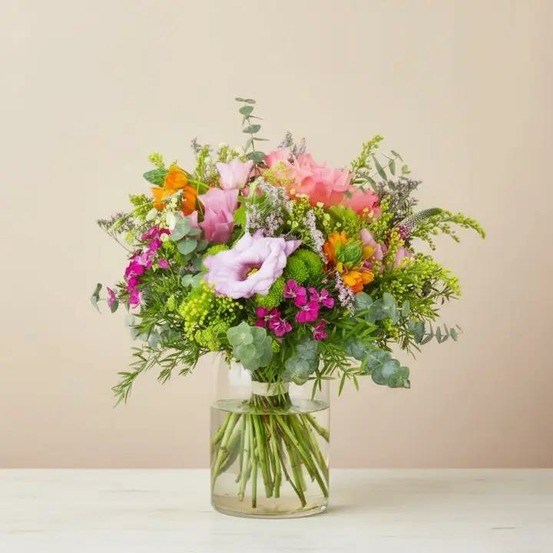 Bouquet de fleurs fraîches avec des roses roses, des lisianthus violets et des fleurs orangées