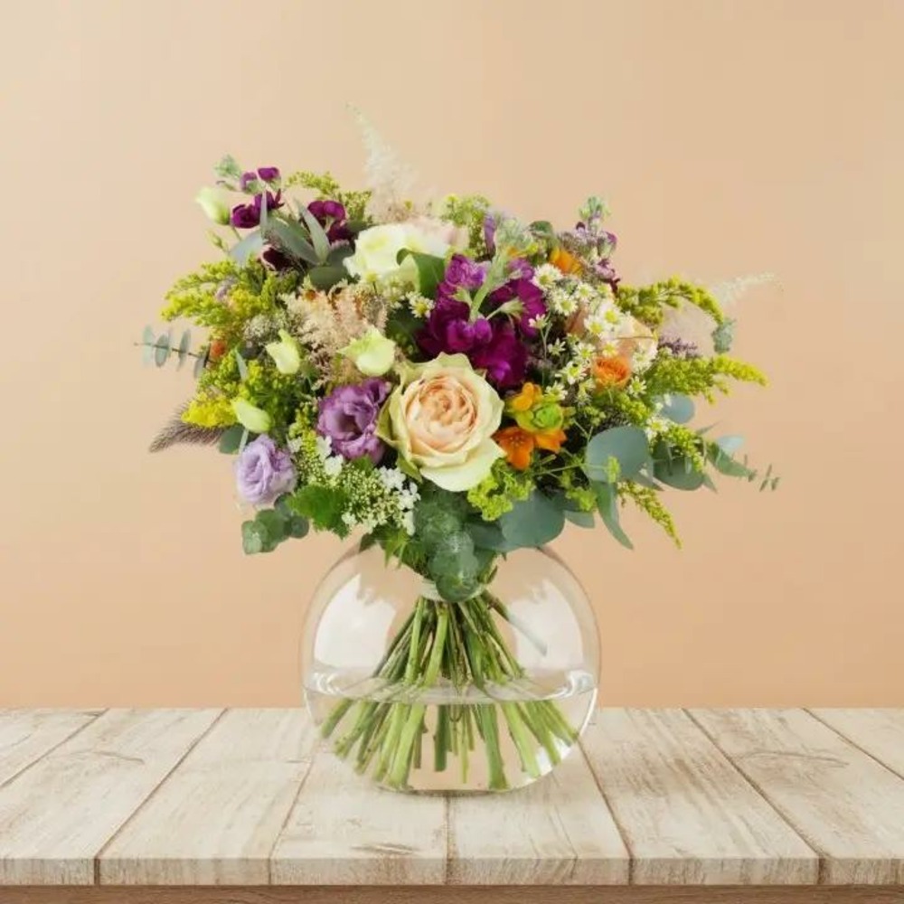 Bouquet de fleurs fraîches avec des roses pêche, des lisianthus violets et du feuillage d’eucalyptus