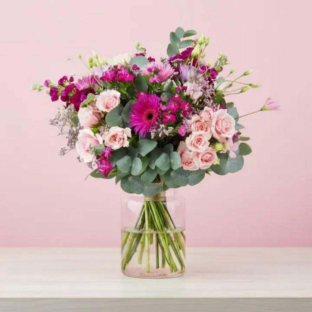 Bouquet de fleurs fraîches avec des roses roses, des germinis fuchsia et du feuillage d’eucalyptus