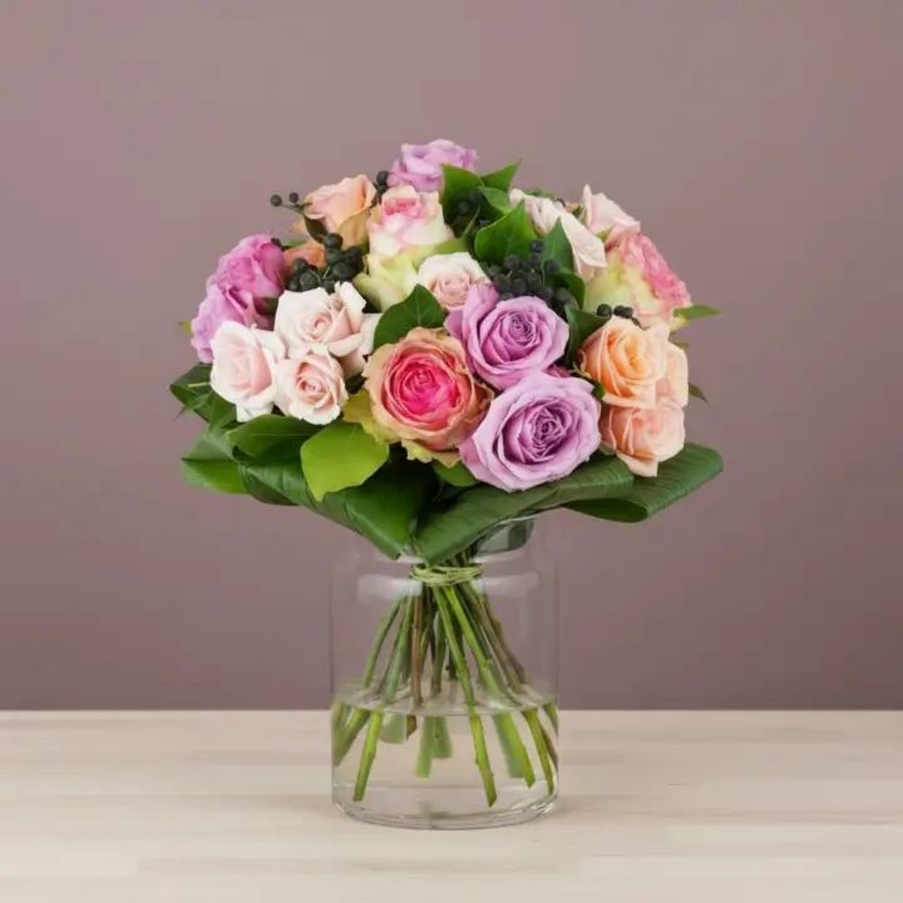 Bouquet de fleurs fraîches avec des roses roses, des roses pêche et du feuillage vert